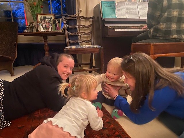 Cara playing on the floor with family