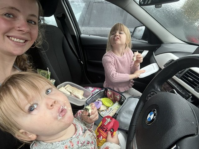 Cara, Eliza and Mummy having a snack in the car